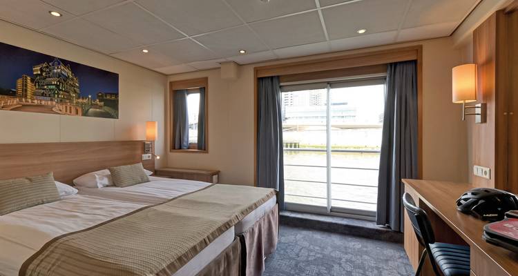 Modernes Hotelzimmer mit Doppelbett und Schreibtisch.