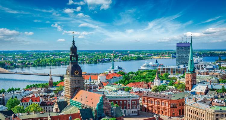 Stadtsilhouette mit Fluss und hohen historischen Gebäuden.