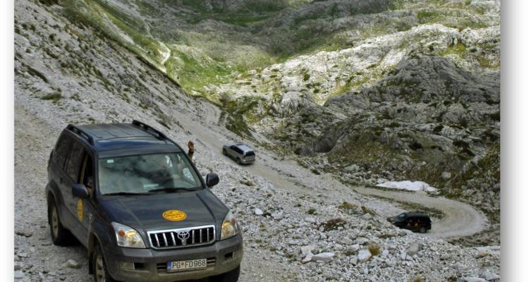 Off-road vehicles on a rugged mountain path.