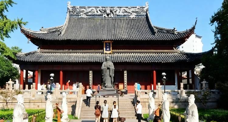 Traditional Chinese temple with large statue and visitors.