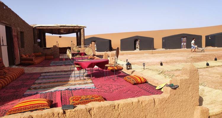 Outdoor seating area with colorful cushions in a desert camp.