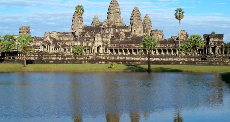 Angkor Wat, a large temple complex with a reflection in a pond.