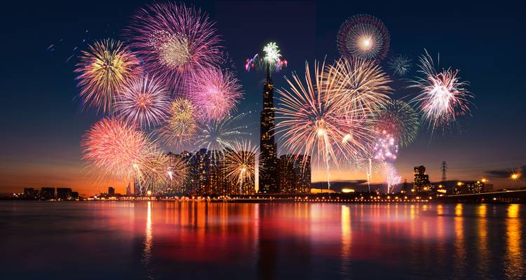 Fireworks display over a city skyline at night.