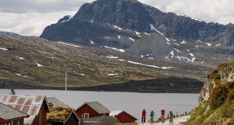 Cyclistes sur une route avec des montagnes en arrière-plan.