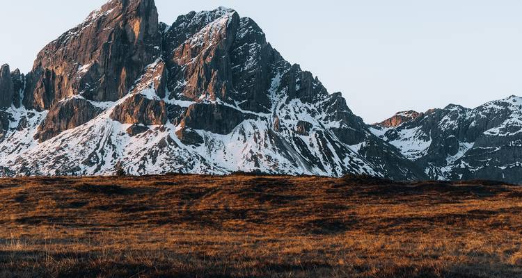 Close-up of a snowy mountain peak against a clear sky.