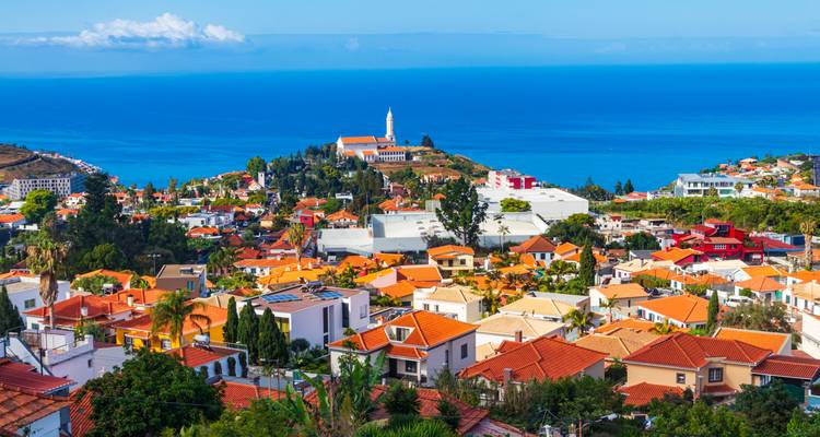 Panoramic coastal town with orange-roofed houses overlooking the Atlantic Ocean and a small hilltop church