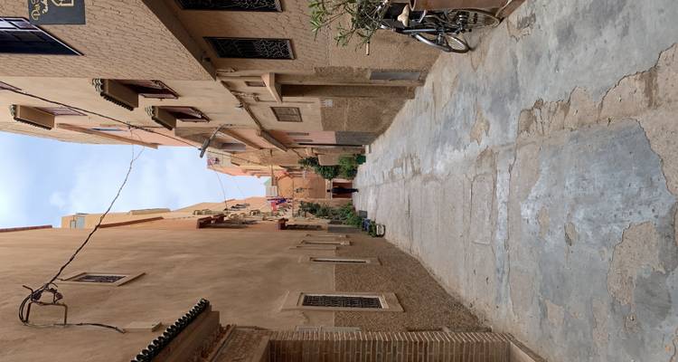 Narrow alleyway in a town with a person walking at the end.