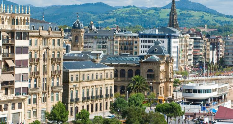 Cityscape of San Sebastian with distant hills and various buildings.