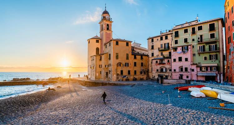 Seaside village during sunset with colorful houses.