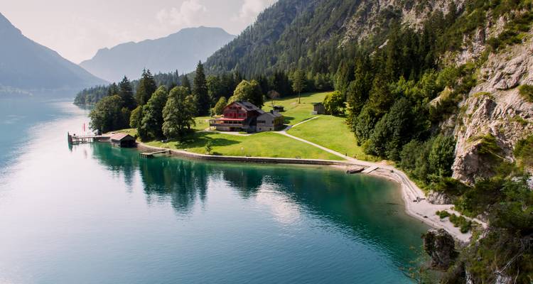 See mit einer Holzhütte und üppiger Landschaft