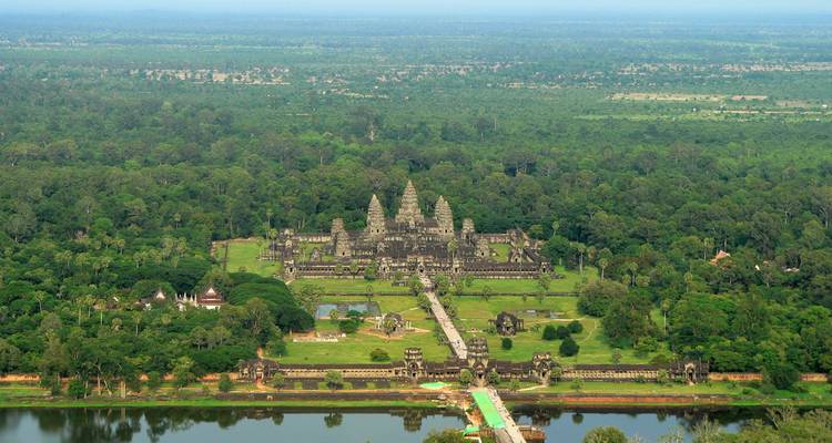 Aerial view of Angkor Wat surrounded by forests and water.