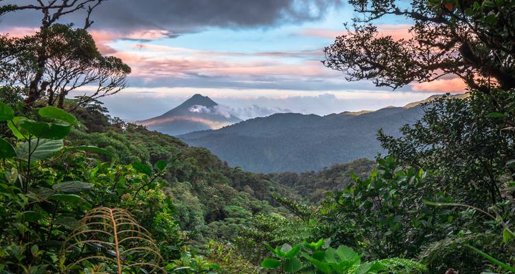 Vallée verdoyante luxuriante avec un volcan en forme de cône au loin.