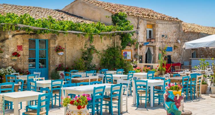 Charmantes Outdoor-Restaurant mit blauen Stühlen.