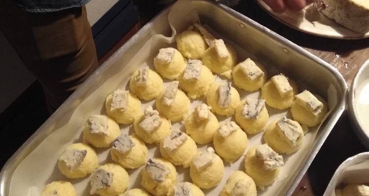 Tablett mit ungekochten Fleischbällchen mit Käse obendrauf wird zubereitet.