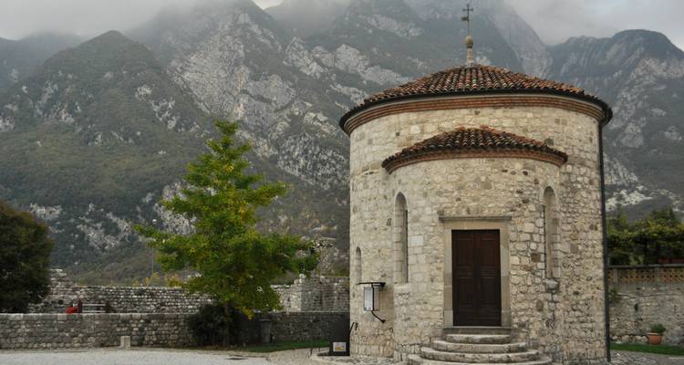 Steinernes Rundgebäude mit Bergkulisse.