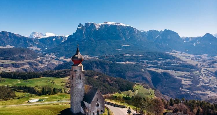 Schilderachtig luchtfoto van alpine kapel met uiendak tegen het dramatische berglandschap van de Dolomieten.