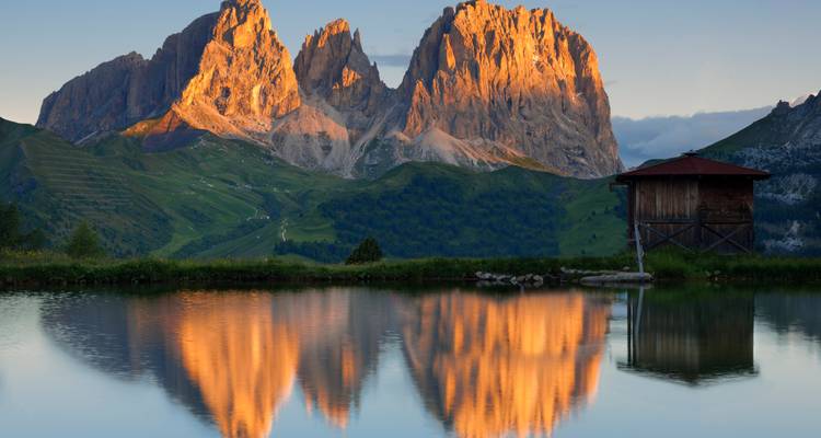 Reflecterend meer met bergtoppen bij zonsondergang.