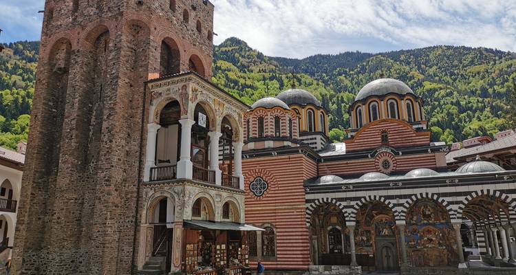 Historisch klooster met sierlijke architectuur en bergen.
