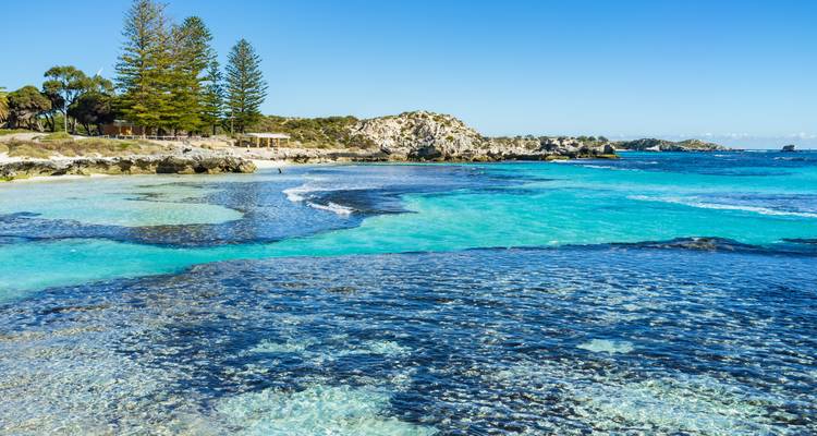 Turquoise waters with rocky shores and distant trees.