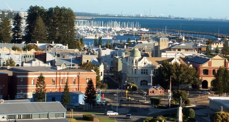 Cityscape with historic buildings and a distant marina.