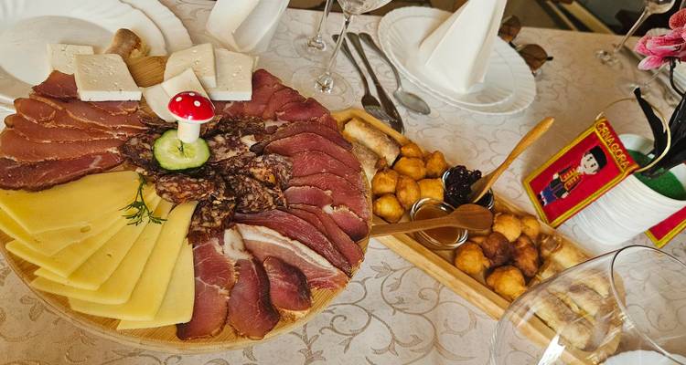 Close-up of a food platter with cheese, meat, and pastries on a table.