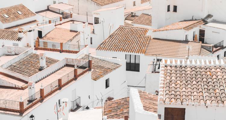 Daken van witte huizen met terracotta tegels.