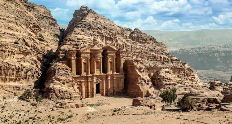 Ikonisches Kloster von Petra, das in eine ragenden Sandsteinklippe gehauen ist und von rauen Bergen umgeben ist.