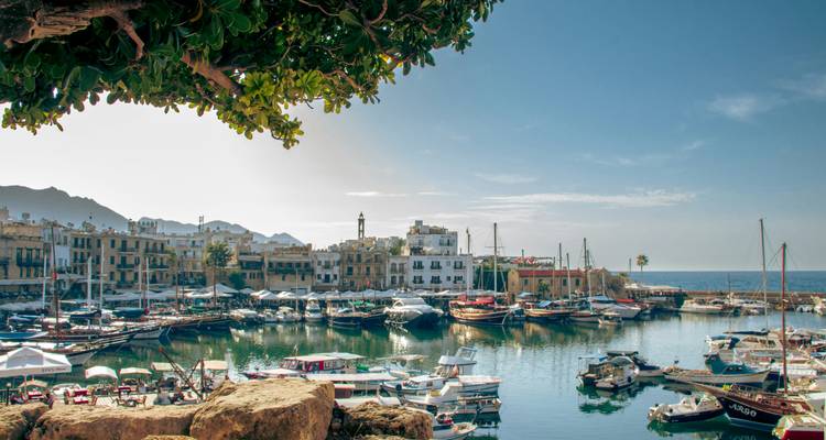 Beau port avec des bateaux et des bâtiments historiques sous un ciel bleu.