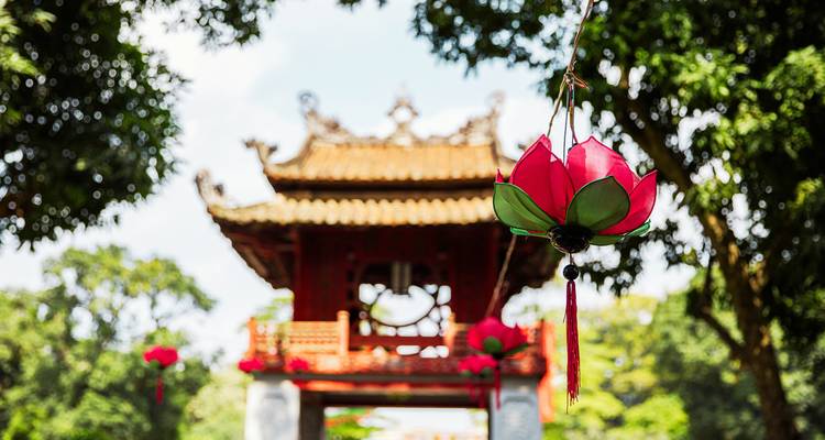Dekorative Laternen hängen vor einem kunstvollen Tempeltor.