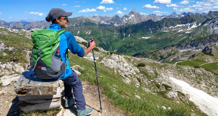 Randonneur se reposant sur un banc en admirant le paysage de montagne.