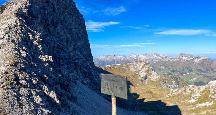 Panneau de signalisation de montagne avec vues panoramiques sur les sommets.