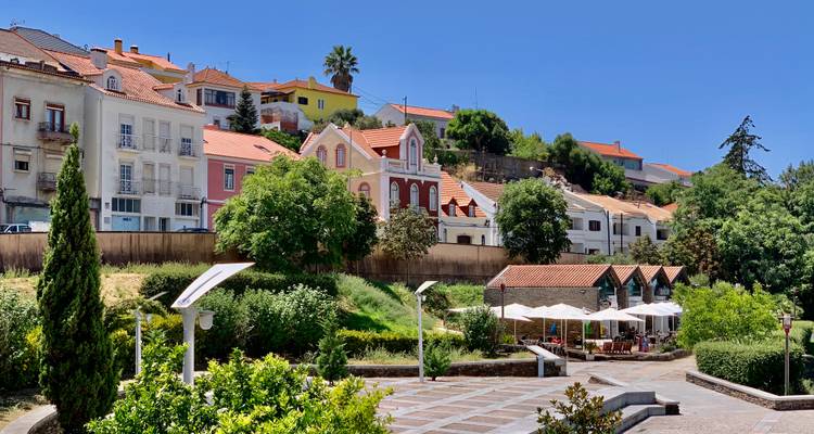 Malerische Stadt am See mit bunten Gebäuden und Hügeln.