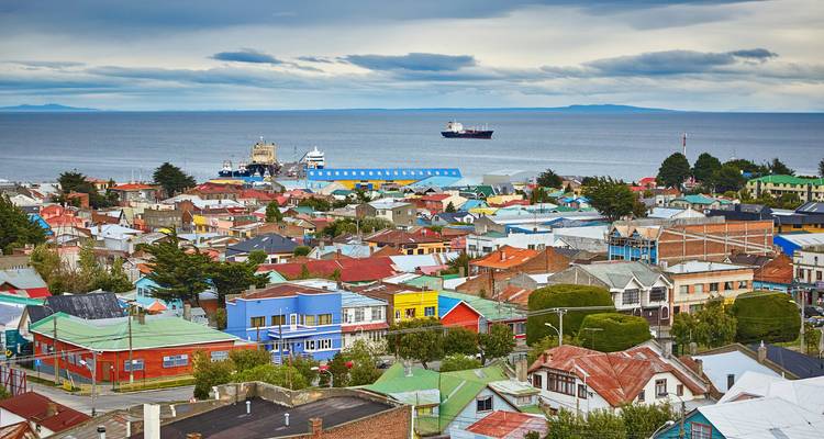 Een kuststad met kleurrijke gebouwen en schepen in de haven.
