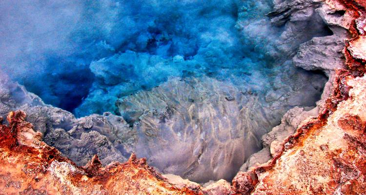 Een close-up van een hete bron met heldere blauwe en oranje kleuren.