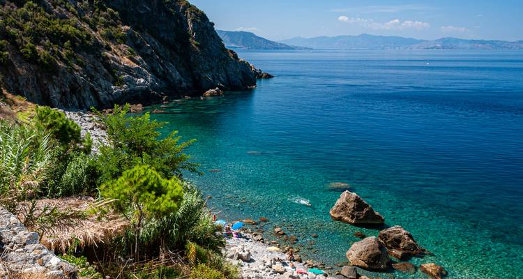 Una vista costera serena con aguas cristalinas y colinas exuberantes.