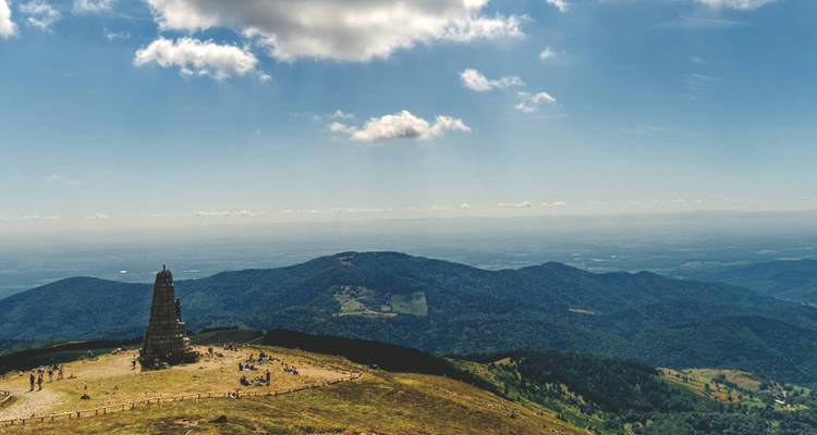 Monument op een heuveltop met panoramisch bergzicht.