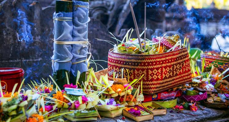 Traditional Balinese offerings with intricate woven baskets and incense.