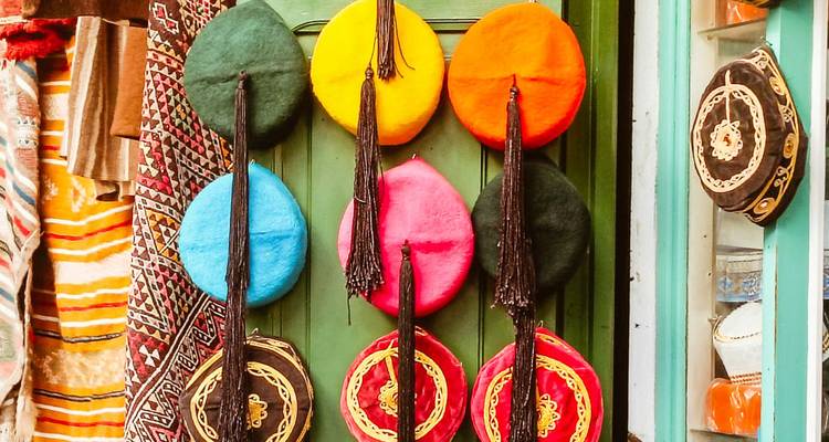 Chapeaux de laine colorés exposés sur un mur.