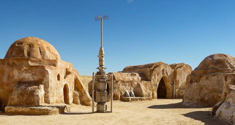 Décor de film de science-fiction avec des structures désertiques et un ciel dégagé.