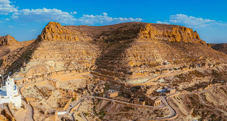 Vue panoramique d'un village du désert sur un terrain montagneux.