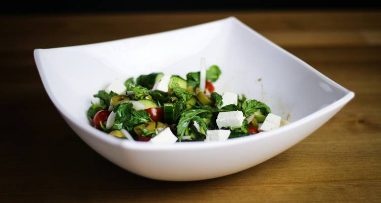 Tazón de ensalada con queso y verduras.