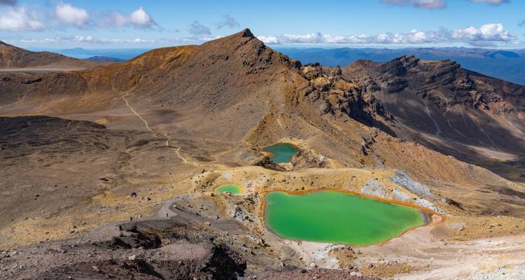 Smaragdgroene meren met ruige bergachtergrond.