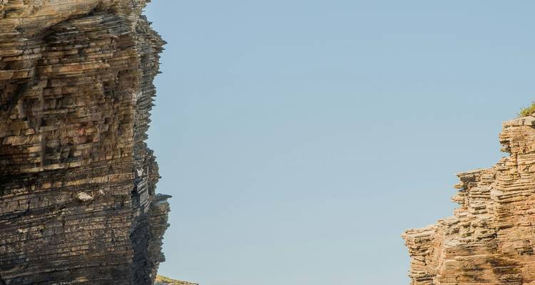 Formation rocheuse naturelle avec des falaises déchiquetées contre un ciel dégagé.