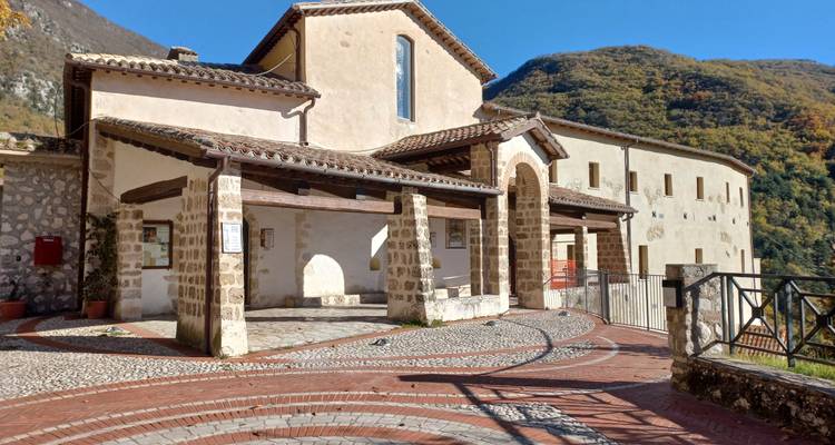 Bâtiment historique avec des entrées voûtées par une journée ensoleillée.