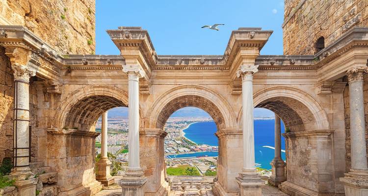 Arcos de piedra antigua enmarcan una vista costera impresionante de Antalya y el mar azul profundo