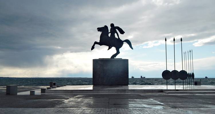 Silhouette of an equestrian statue against the sea.