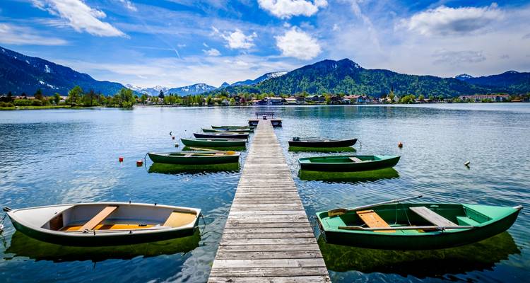 Muelle con botes de remo en un hermoso lago alpino.