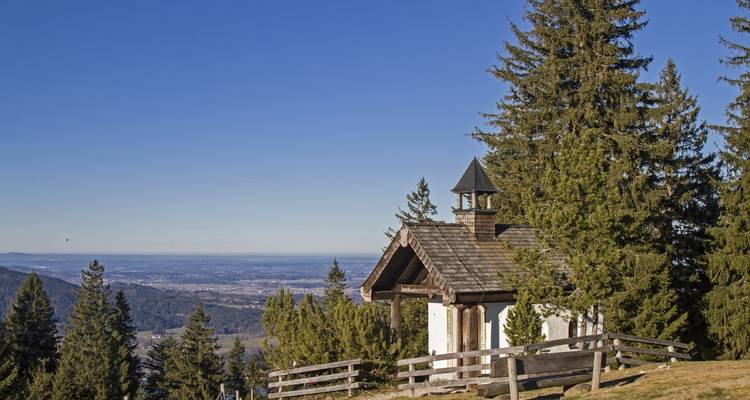 Pequeña capilla en una colina con vista a las llanuras de abajo.