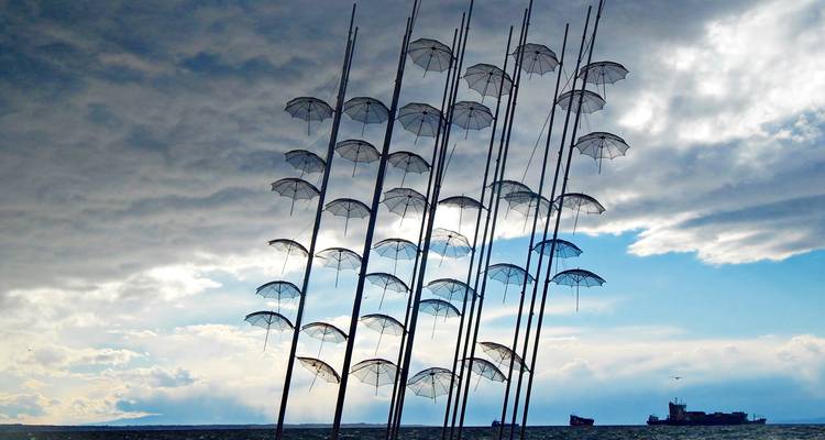 Unique sculpture installation with umbrellas by the sea.