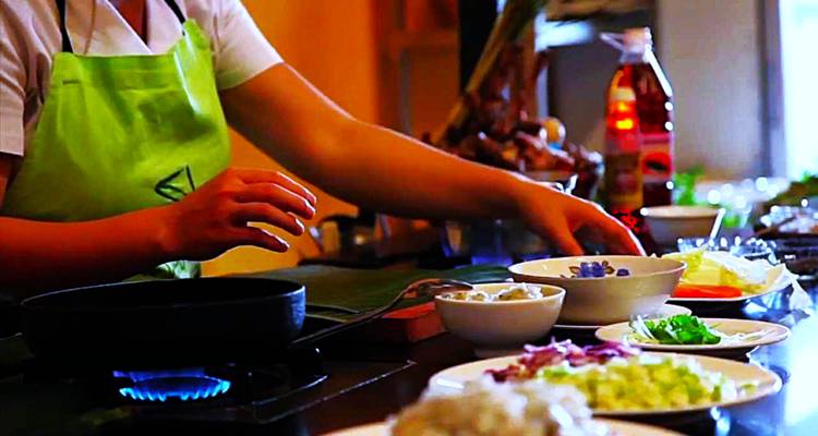Person cooking in a kitchen with ingredients laid out.